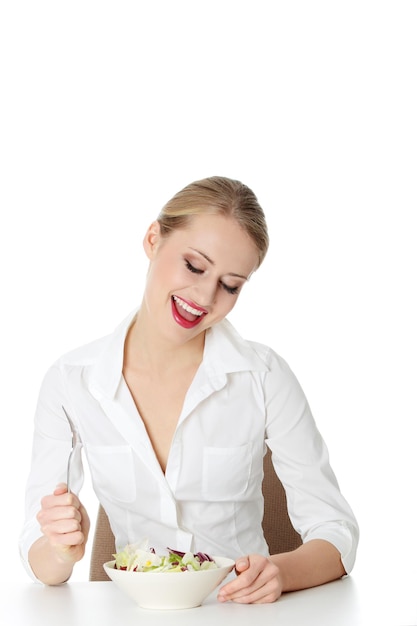 Uśmiechnięta osoba jedząca sałatkę